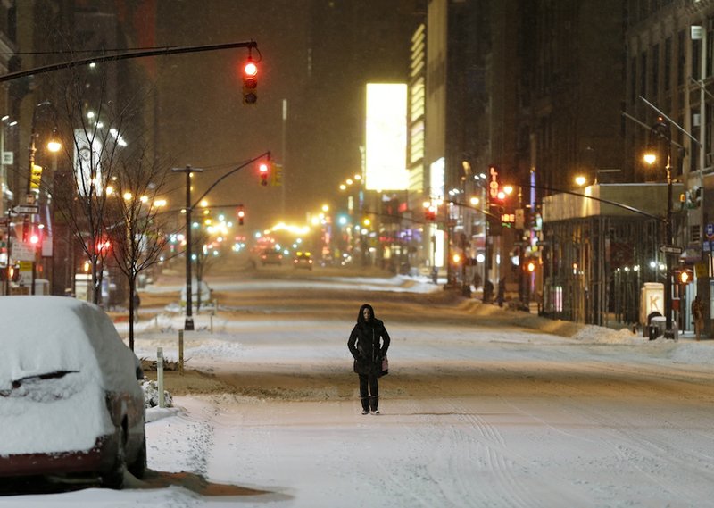 A woman walks down the middle of Eighth Avenue near Times Square in New York, early Tuesday, Jan. 27, 2015. A storm packing blizzard conditions spun up the East Coast early Tuesday, pounding parts of coastal New Jersey northward through Maine with high winds and heavy snow. 