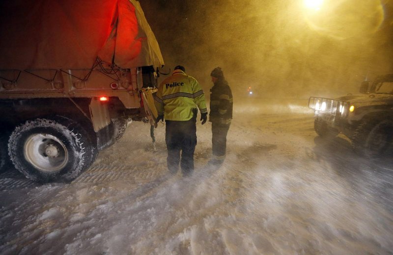 Police and fire personnel prepare to deploy to flooded areas on the coast in Scituate, Mass., Tuesday, Jan. 27, 2015. A storm packing blizzard conditions spun up the East Coast early Tuesday, pounding parts of coastal New Jersey northward through Maine with high winds and heavy snow. 