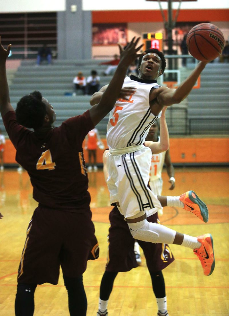 Little Rock Hall’s Eric Daily (5) drives and shoots over Lake Hamilton’s Jason Burns (4) in the fi rst half of their game Tuesday night at George Cirks Arena at Hall High School.