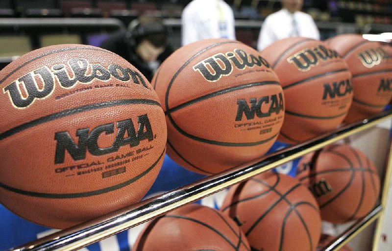 In this file photo, Wilson basketballs sit in a rack before an NCAA college basketball tournament first round game. (AP Photo/Phil Coale)