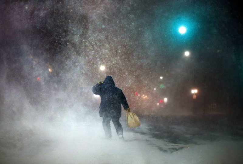 A man fights a fierce head wind Tuesday evening in Portland, Maine, as a strong winter storm swept over New England with high winds and whiteout conditions. Though Long Island, N.Y., was hit hard, the blizzard spared the New York City area, leaving forecasters apologizing for their dire warnings and officials defending a near-total shutdown on travel. 