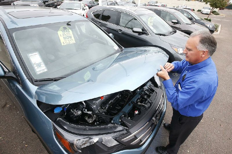 Mike Johnson, a sales manager at a Honda dealership in Tempe, Ariz., raises the hood on a Honda CRV last month. Orders for long-lasting manufactured goods fell in December, the Commerce Department said. 