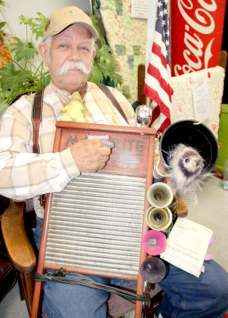 PHOTOS/LYNN KUTTER ENTERPRISE-LEADER Jack Thompson plays a washboard in the Kitchen Band with all sorts of items attached to it for other sounds. The weasel inside the larger horn jumps out and makes squeaky noises to add to the music.