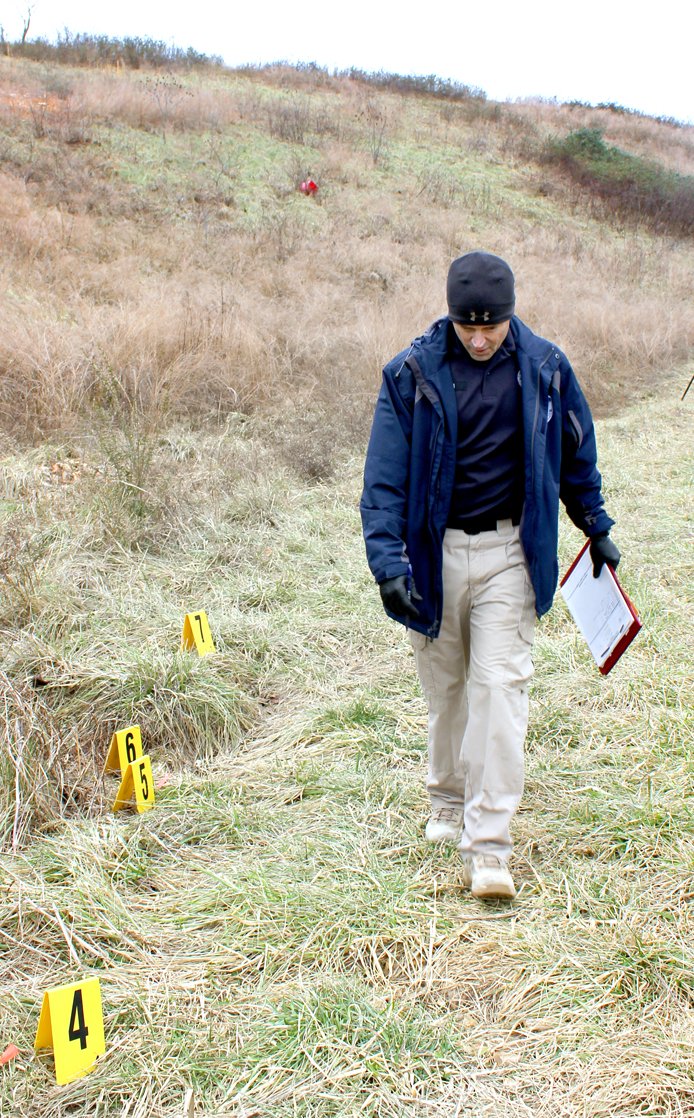 Tina Parker/Herald-Leader Siloam Springs Detective Derek Spicer scans the ground for evidence during a child abduction training exercise.