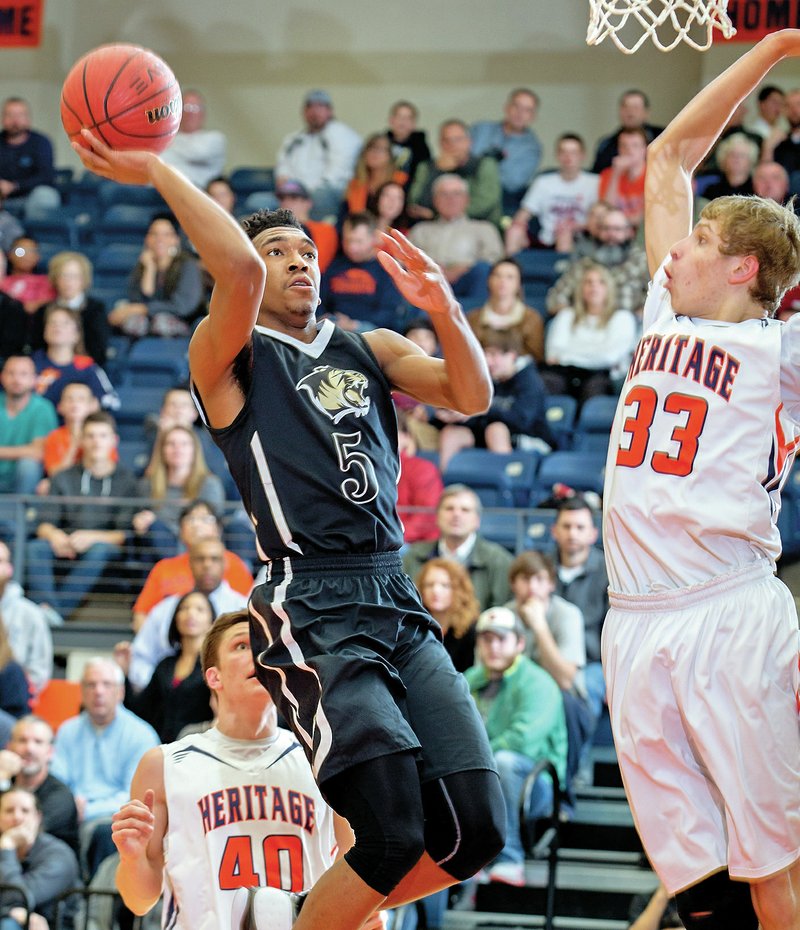 Bentonville’s Malik Monk (left) takes the ball to the basket Jan. 27 against Rogers Heritage in Rogers.