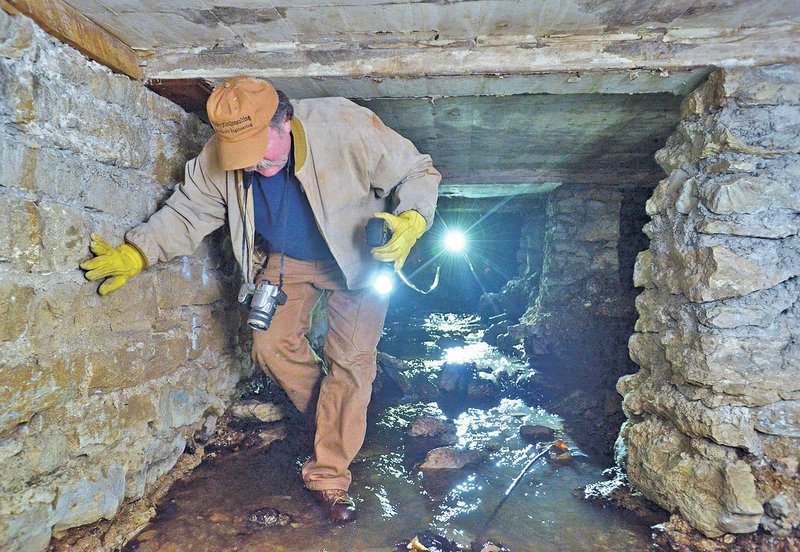 Dee Purkeypile, a dam safety engineer, makes his way Jan. 21 through the foundations of The Auditorium as engineers and city officials tour of the storm drains under downtown Eureka Springs. 
