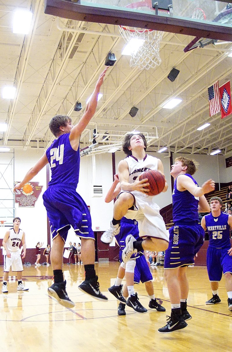 Cole Cripps, Gentry sophomore, goes airborne past Berryville defenders for a shot under the basket during play between the two teams in Gentry on Jan. 27, 2015.