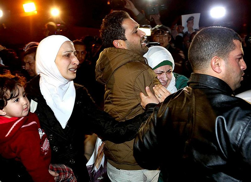 During a protest Wednesday outside the Royal Palace in Amman, Jordan, a man comforts the wife of Jordanian pilot Lt. Muath al-Kaseasbeh, who is being held under threat of death by Islamic State militants. 