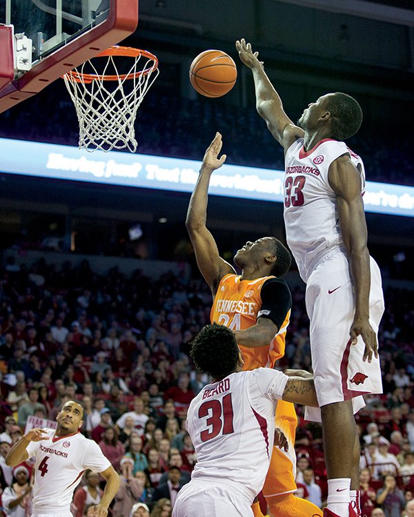 The Associated Press IN TRAFFIC: Tennessee forward Willie Carmichael III, center, shoots a layup as Arkansas forward Moses Kingsley goes for the block in first-half action Tuesday night at Walton Arena in Fayetteville. Winning 69-64, Arkansas improved to 5-2 in the Southeastern Conference and handed Tennessee its first SEC road loss this season. The Hogs travel to Florida for a noon tip-off Saturday on CBS (Resort Channel 11).