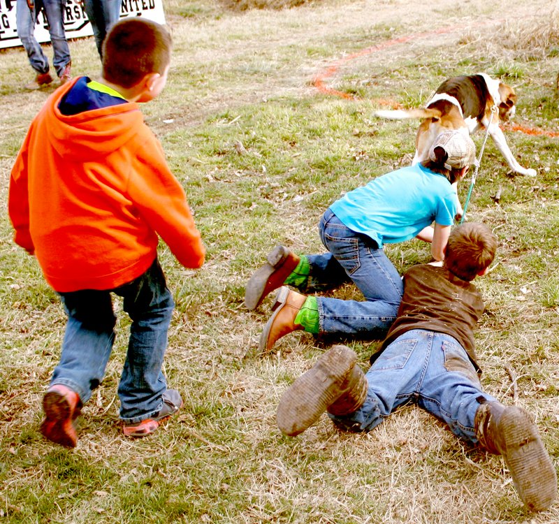 COURTESY PHOTO Three McDonald County youth desperately hang on to their &#8220;adopted&#8221; coon dog during the &#8220;Barking Battle&#8221; segment of the daylong of activities at the Young Outdoorsmen United youth rabbit and coon hunt held Jan. 17 near Southwest City.