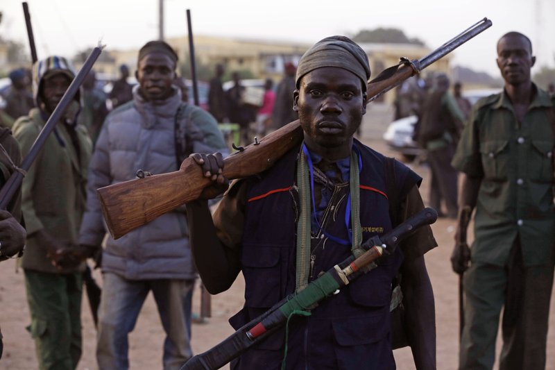 In this file photo taken on Wednesday, Nov. 25, 2014, vigilantes and local hunters armed with locally made guns gather before they go on patrol in Yola, Nigeria,  Islamic extremists are rampaging through villages in northeast Nigeria's Adamawa state, killing, burning and looting with no troops deployed to protect civilians, fleeing villagers said Wednesday, Jan. 28, 2015.