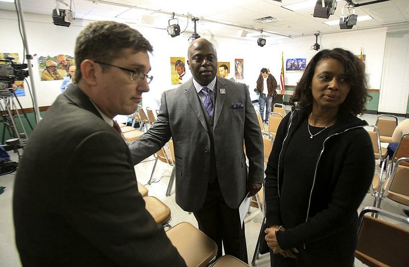 Jim Ross (left) and Joy Springer, two members of the now-dissolved Little Rock School Board, talk Thursday with Dexter Suggs, now the interim superintendent of the Little Rock School District, after a news conference on how the district will proceed under state control. 