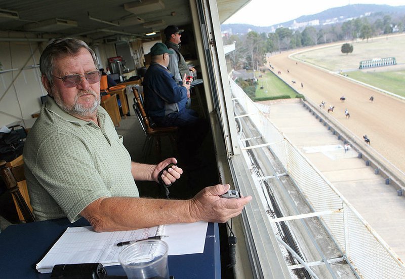 The Sentinel-Record/Richard Rasmussen KEEPING TIME: Head clocker Jim Hamilton times thoroughbreds from the press box as they work out on Thursday at Oaklawn Park. Hamilton leads a team of four people who record morning workouts seven days a week during the live race meet.