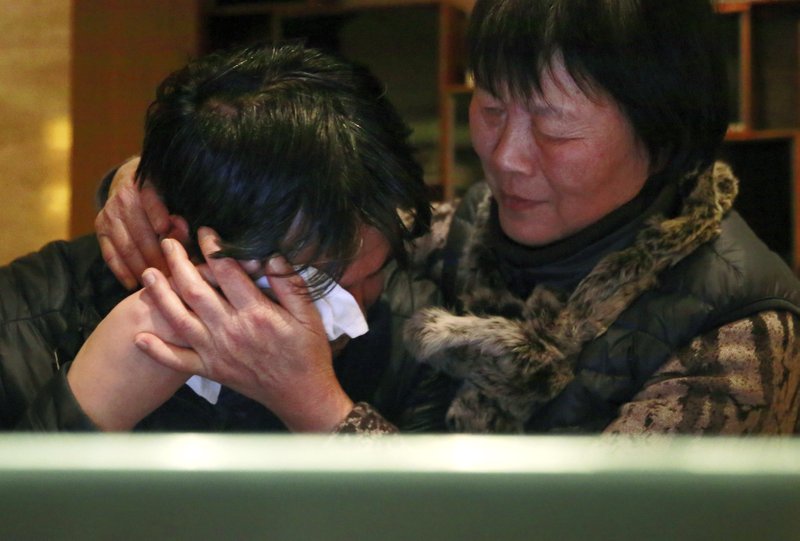 Jiang Hui, left, is comforted Thursday by Dai Shuqin after watching a pre-recorded message broadcast on Malaysian television by Malaysia’s Civil Aviation Authority from a laptop computer in Beijing. Both are relatives of passengers onboard the Malaysia Airlines Flight 370 that went missing on March 8, 2014. 