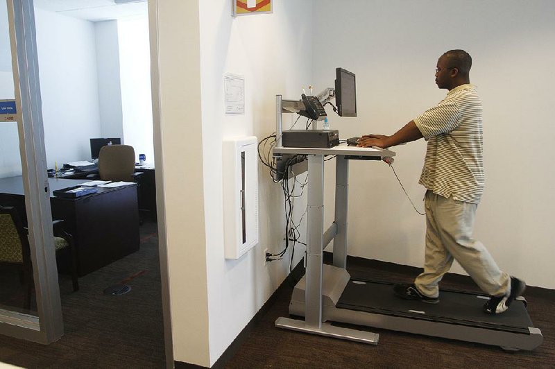 BlueCross BlueShield employee Jeffery Choice works and walks on one of two treadmill workstations in its complex on Thursday afternoon. Employees are welcome to take turns walking and working simultaneously, in an effort to improve employee health and beat “the afternoon slump.” 