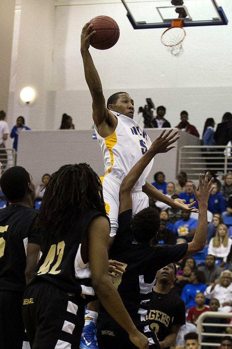 North Little Rock 86, Little Rock Central 55 North Little Rock guard Kevaughn Allen (5) elevates to the rim among several Little Rock Central defenders during Friday night’s 7A/6A-East Conference game. Allen scored 19 points to lead the Charging Wildcats to their eighth victory over the past nine games, keeping them a game behind Jonesboro for first place in the conference.