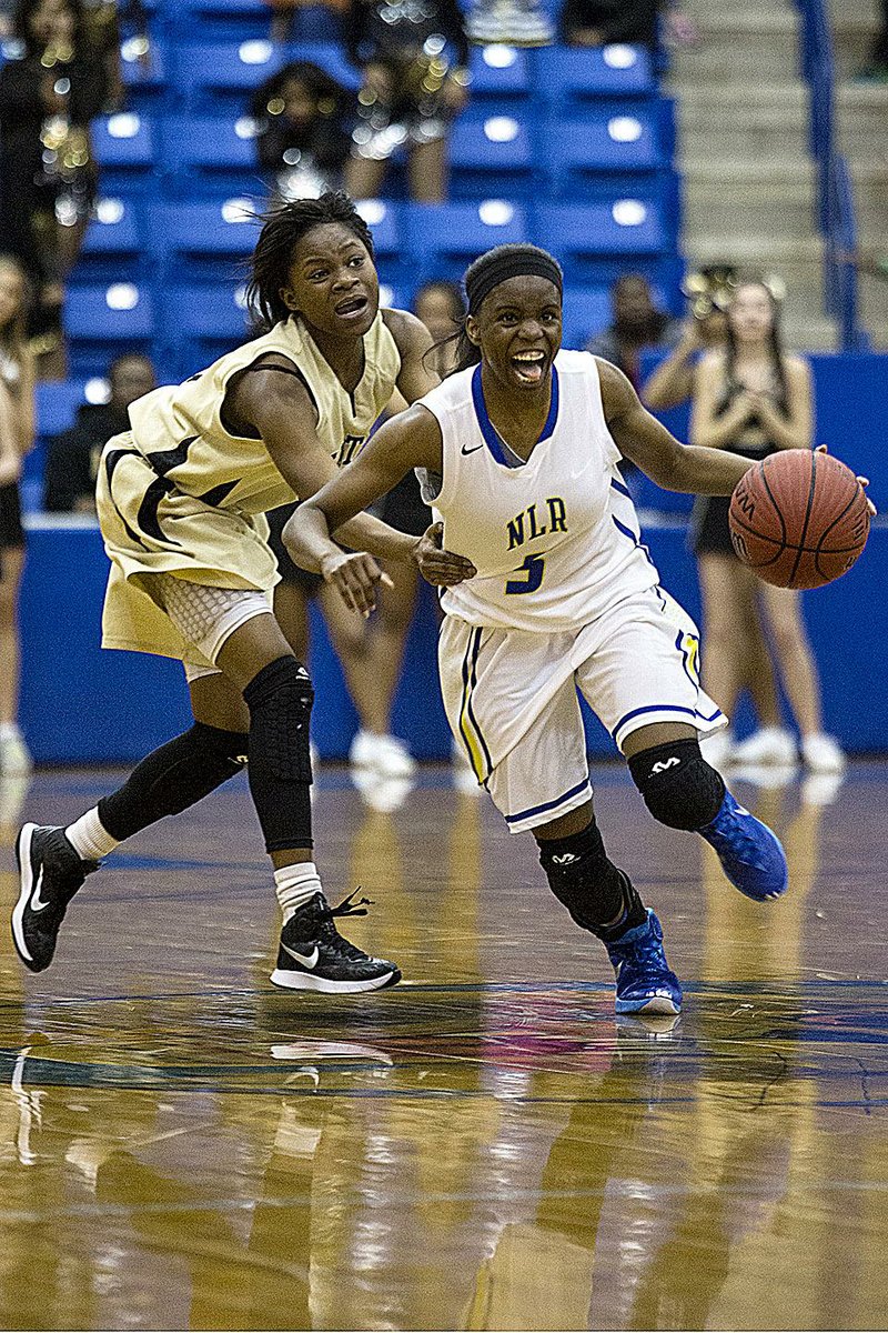 North Little Rock’s Malica Monk dribbles out the final seconds in front of Little Rock Central’s Alexsis Brown during the Lady Charging Wildcats’ 71-68 victory Friday night. Monk converted a three-point play with 15 seconds remaining to give North Little Rock the victory.