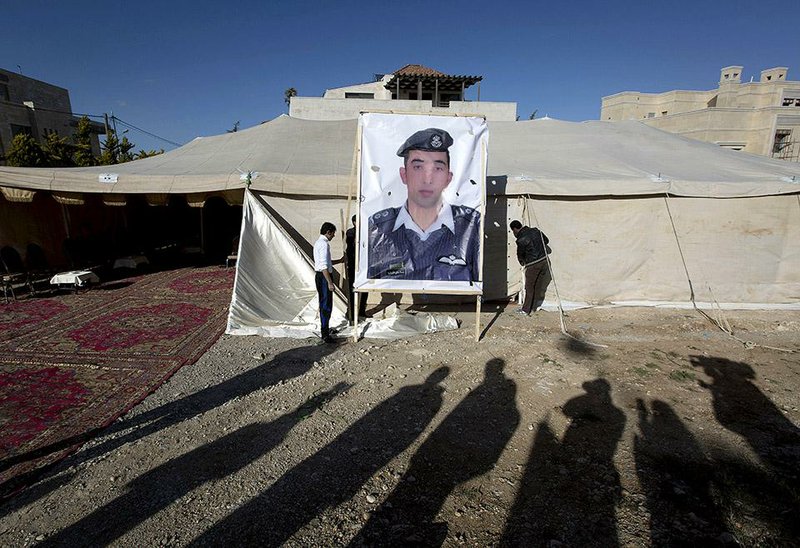 A banner bearing a picture of Jordanian pilot Lt. Muath al-Kaseasbeh, a captive of Islamic State militants, is raised Friday in Amman. The pilot’s fate and that of Japanese journalist Kenji Goto are still unknown as the latest reported deadline for a prisoner swap passed. 