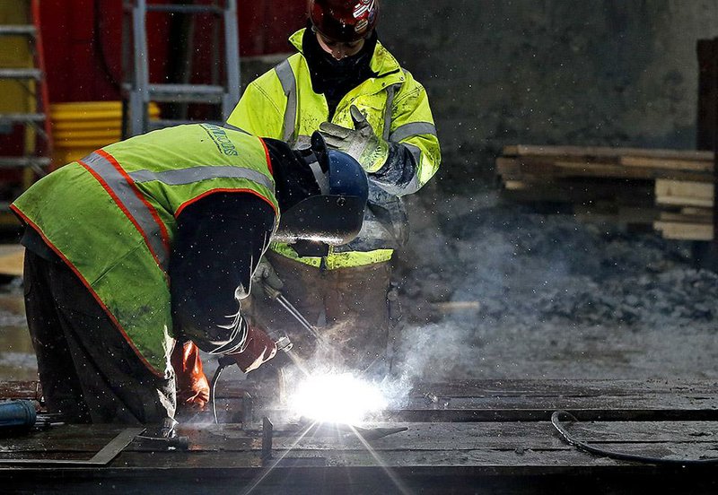 Welders work at a commercial construction site in Boston earlier this month. The U.S. economy grew at a 2.6 percent annual rate in the fourth quarter, the Commerce Department said Friday. 