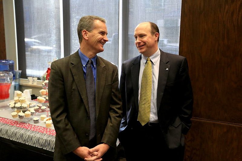 Brett Powell (left), new director of the state Department of Higher Education, and Jay Jones, interim chancellor at the University of Arkansas at Monticello, chat Friday at a meeting of the Higher Education Coordinating Board in Little Rock. 