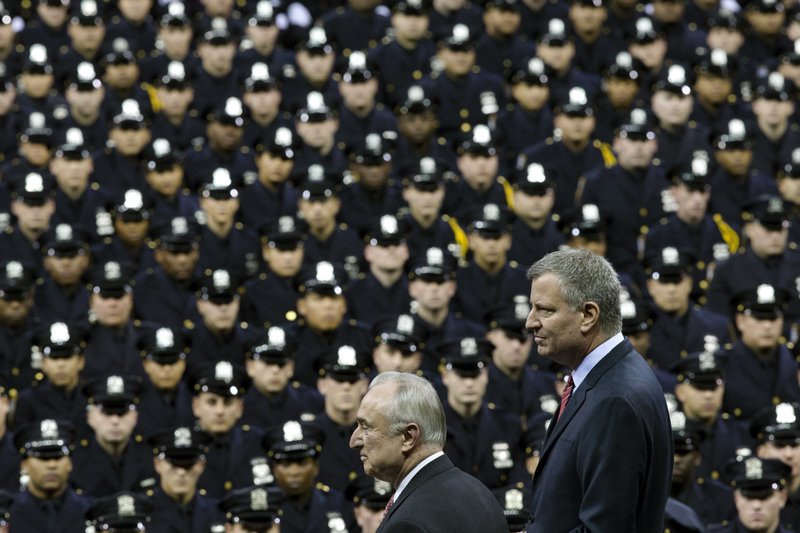 Moving on: New York City Mayor Bill de Blasio, right, and NYPD police commissioner Bill Bratton, center, stand on stage during a New York Police Academy graduation ceremony at Madison Square Garden in New York. Mayor Bill de Blasio declares he has moved past the crisis with police that threatened to derail his administration.