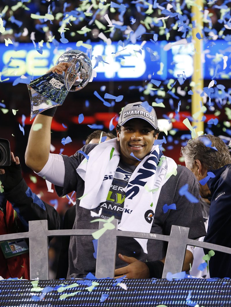 In this Feb. 2, 2014, file photo, Seattle Seahawks quarterback Russell Wilson holds up the Lombardi Trophy after beating the Denver Broncos 43-8 in the NFL Super Bowl XLVIII football game at MetLife Stadium in East Rutherford, N.J. Its never been harder than in this salary-cap, free-agency era of parity for an NFL team to win two Super Bowls in a row, something the Seahawks will achieve Sunday if they can beat the New England Patriots, the last club to do it, a decade ago.