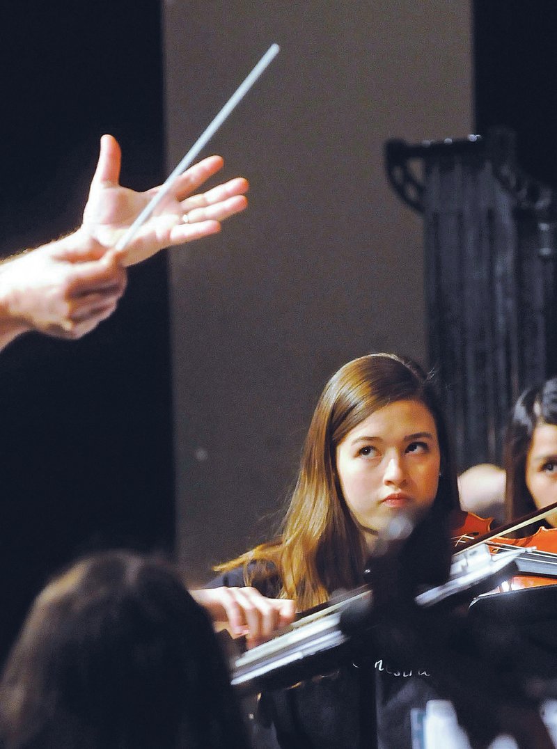 NWA Democrat-Gazette/FLIP PUTTHOFF Virginia Paschal plays violin Tuesday while Bill Rowan directs the Rogers High School orchestra students during a performance for fifth-graders.