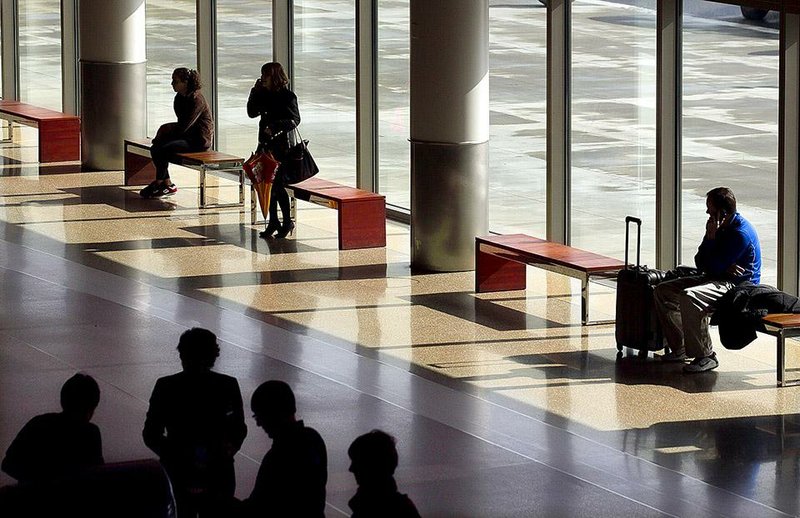 Arkansas Democrat-Gazette/BENJAMIN KRAIN --02/1/2015--
Airline passengers wait in the ticketing lobby of the Bill and Hillary Clinton National  Airport Sunday. Despite a loss of more than 90,000 passengers and a decline in operating revenue of nearly $500,000, as well as an increase of $500,000 in operating costs, the state's largest airport finished 2014 with a $1.2 million net income increase.