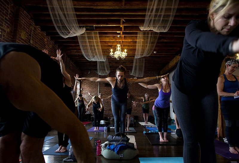 Arkansas Democrat-Gazette/MELISSA SUE GERRITS - 01/25/2015 - Marcus Goodwin, center, and other attendees to a workshop in Little Rock, raise to position during an exercise about breathing during yoga. The workshop was hosted by renowned instructor David Swenson who specializes in Ashtanga yoga. 