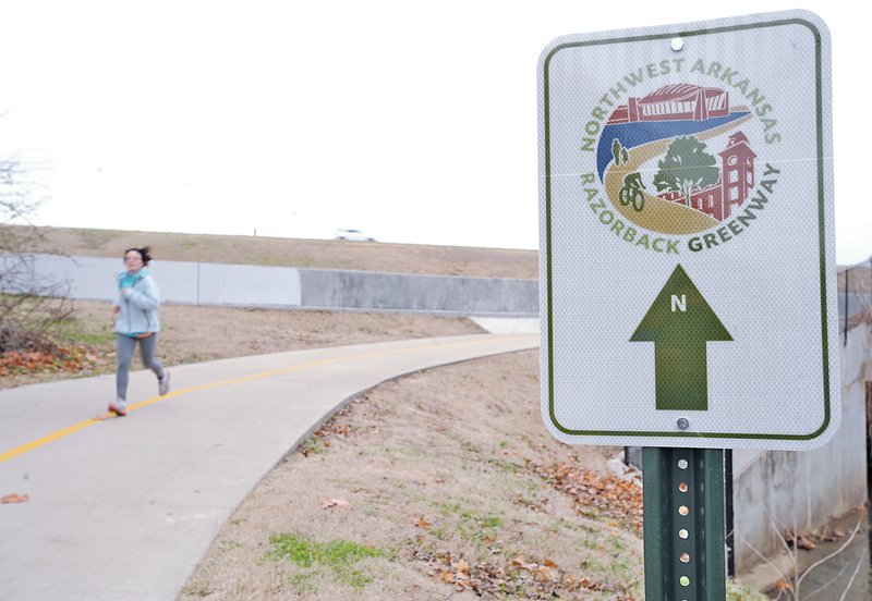  NWA Democrat-Gazette/ANDY SHUPE A runner makes her way south along Fayetteville&#8217;s Scull Creek Trail, a section of the Northwest Arkansas Razorback Greenway, in this Dec. 21 file photo. Officials are looking at early May for the Razorback Greenway ribbon cutting.