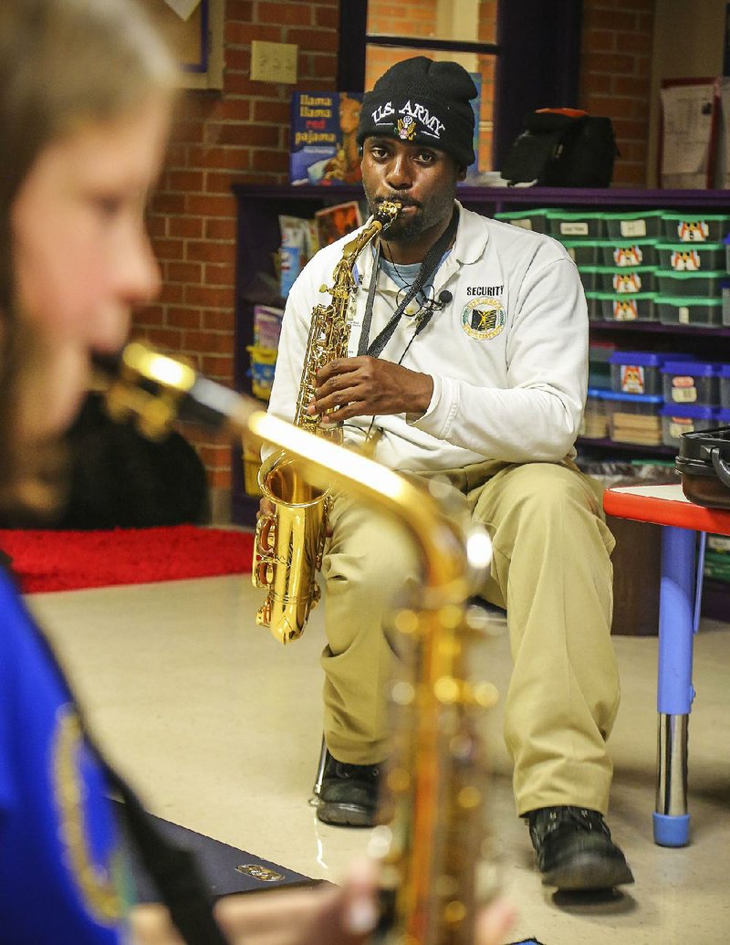 12/4/2014
Arkansas Democrat-Gazette/STEPHEN B. THORNTON
Little Rock School District security officer Chad Henson, plays notes with Thomas Jefferson Elementary school students in an after-school training session in a classroom at the school last December. Henson wanted to share his love of music, specifically the saxophone, with students at his school. The school didn't own or teach the saxophone so Henson reached out to the non-profit Art Porter Music Education (APME) for help. APME teamed up with North Little Rock's Saied Music Company to loan 4 instruments to the school and Henson volunteered to tutor the students after school.