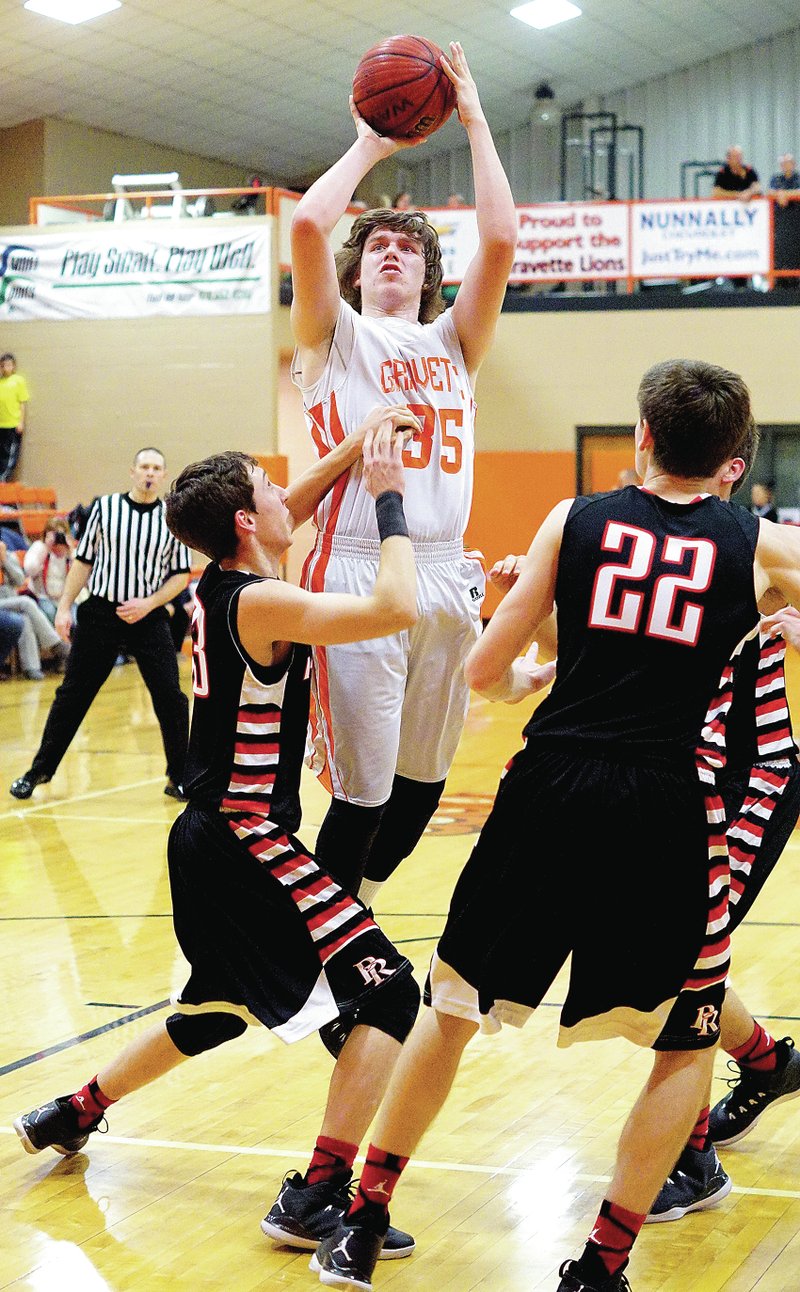 Photo by Randy Moll Cole Turner, Gravette senior, went up for a shot while defended by Zach Davis and Blake Sheppard, Pea Ridge seniors, during play between the two teams in Gravette on Friday.