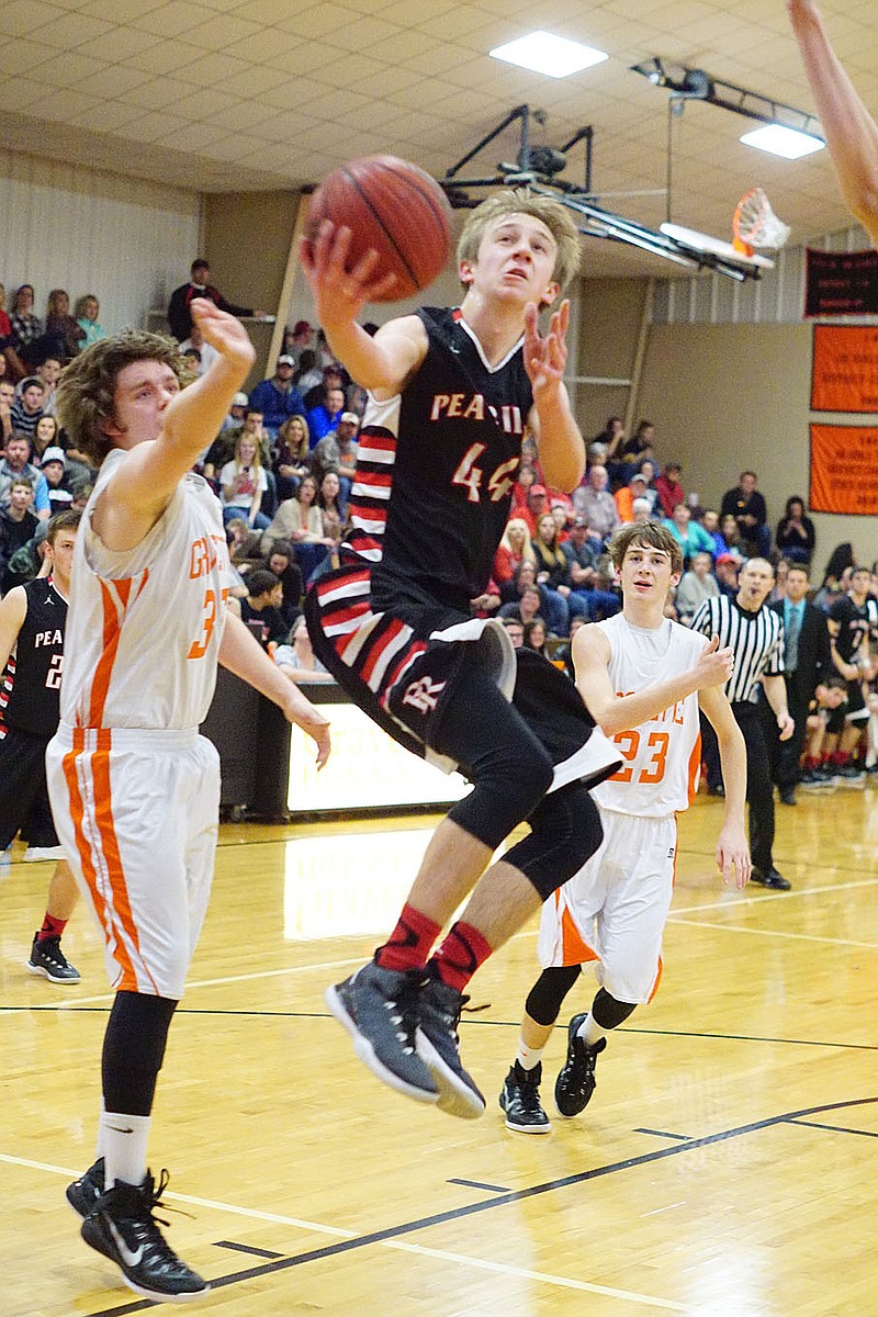 Photographs by Randy Moll Pea Ridge sophomore Joey Hall bounds for a shot under the basket during play between Pea Ridge and Gravette at Gravette Friday, Jan. 30, 2015. Hall scored 27 points Friday night.