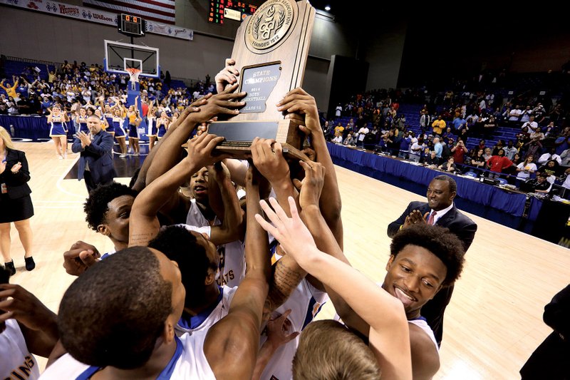 North Little Rock players celebrate after beating Springdale 89-81 to win the Class 7A state basketball title in March 2014. The Arkansas Activities Association announced Thursday that an ineligible player played on North Little Rock’s football and basketball teams, resulting in the school’s forfeiture of all 10 victories from the 2013 football season and at least 24 of the team’s 26 victories during the basketball season, including the Charging Wildcats’ victory in the championship game.