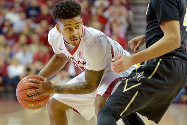 Anton Beard of Arkansas looks to pass as Wade Baldwin, IV of Vanderbilt guards during the first half of the game in Bud Walton Arena in Fayetteville on Saturday Jan. 10, 2015.