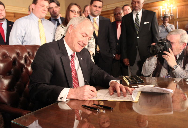 Gov. Asa Hutchinson on Friday, Feb. 6, 2015, signs into law a 1 percent income-tax cut for Arkansans earning between $21,000 and $75,000.