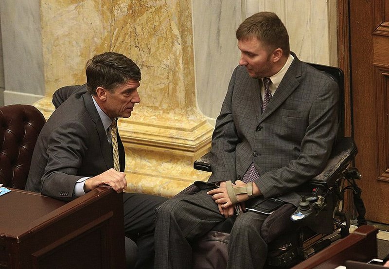 State Rep. Kelley Linck, R-Flippin, (left) speaks with Rep. Josh Miller, R-Heber Springs, before Thursday’s vote on reauthorizing the private option. Linck backed the measure; Miller opposed it. 