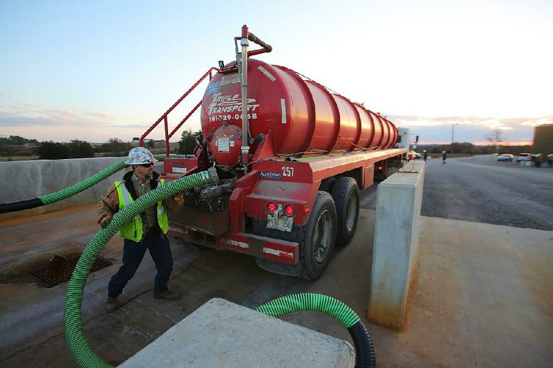 Special to the New York Times/STEPHEN B. THORNTON
Paul Harrison replaces a hose after offloading a truckload of natural gas well production water at a water recycling center operated by Southwestern Energy near Judsonia, Ark. Thursday Nov. 20, 2014. Southwestern Energy contributed to the funding of the project. Southwestern remains commitment to natural gas production, including Arkansas' Fayetteville Shale play, despite low prices and other companies moving to oil. 