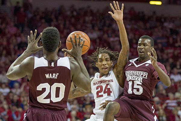 Mississippi State guard JJ Ready, right, passes the ball to Gavin Ware, left, as Arkansas guard Michael Qualls, center, defends during the first half of an NCAA college basketball game on Saturday, Feb. 7, 2015, in Fayetteville, Ark. (AP Photo/Gareth Patterson)