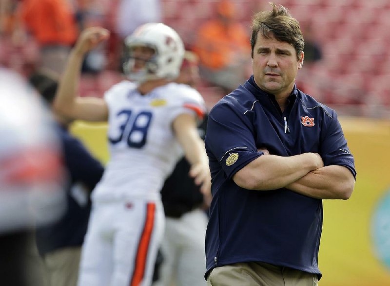 FILE  - Int his Jan. 1, 2015, file photo, Auburn defensive coordinator Will Muschamp watches before the Outback Bowl NCAA college football game in Tampa, Fla. . The former Gators coach, who was fired last season and hired as Auburn's defensive coordinator two weeks after he coached his final game for Florida, has the Tigers in position to make a signing day surge. (AP Photo/Chris O'Meara, File)