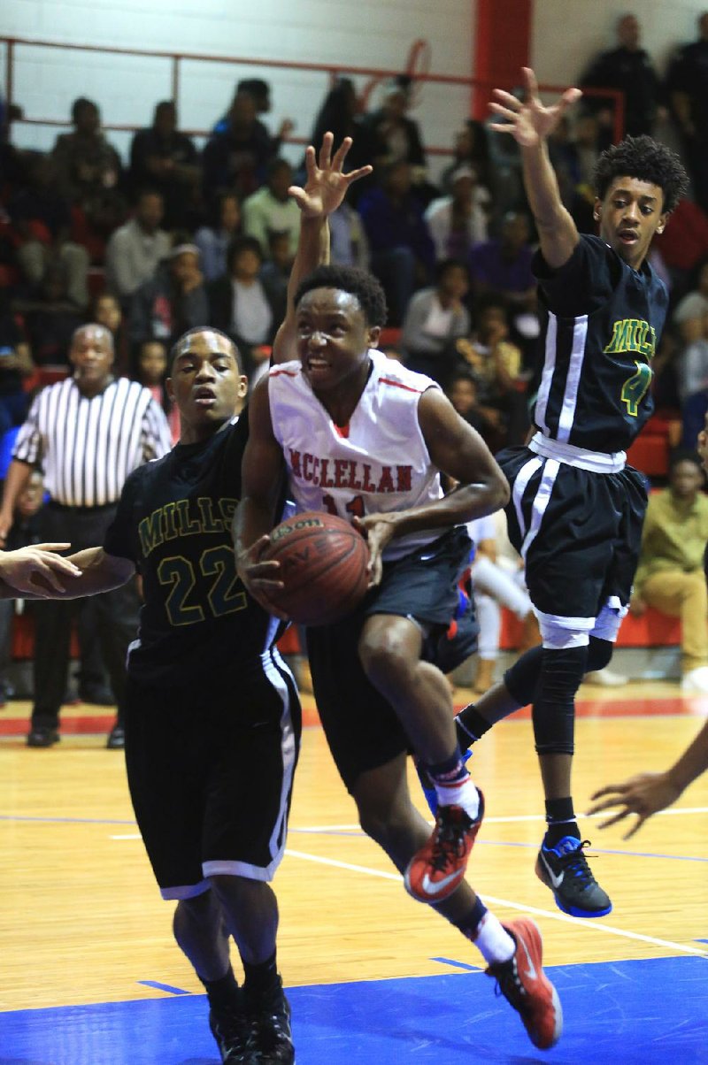 Little Rock McClellan’s Raymond Harris (middle) drives to the basket Tuesday against Mills defenders Rajhon Ware (left) and Jacobe’ Davis during the Lions’ 69-67 victory over the Comets.