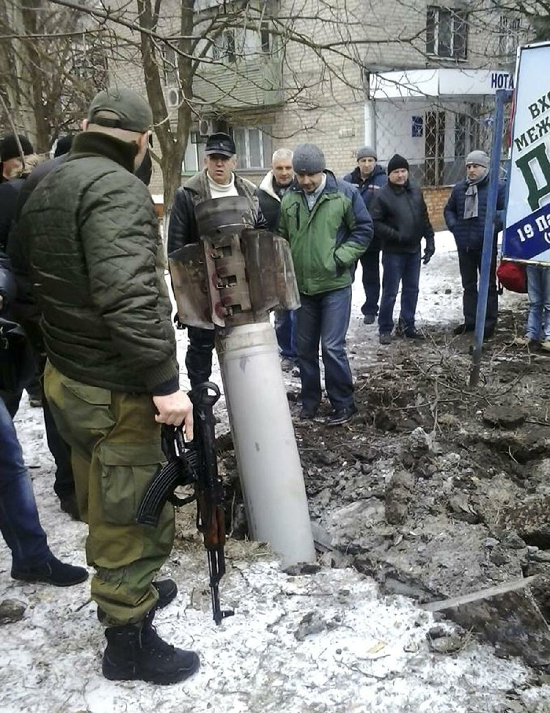 An unexploded rocket rests Tuesday near some homes in Kramatorsk in eastern Ukraine after what the government said was a rebel bombardment that killed 12 people and wounded 64 in the town far behind enemy lines. Fighting intensified Tuesday ahead of peace talks set to begin today in Minsk, Belarus. 