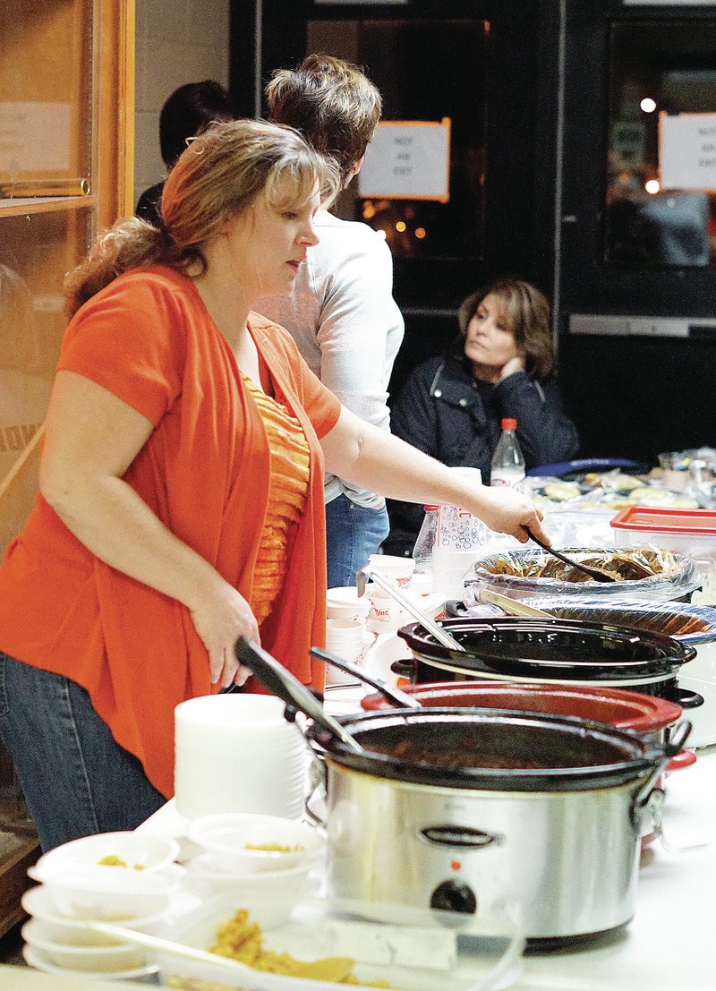 Photo by Randy Moll Annette Dunfee stirs a pot of chili in the serving line of the Project Prom Chili Supper at the Gravette Lions field house on Friday, Jan. 30.