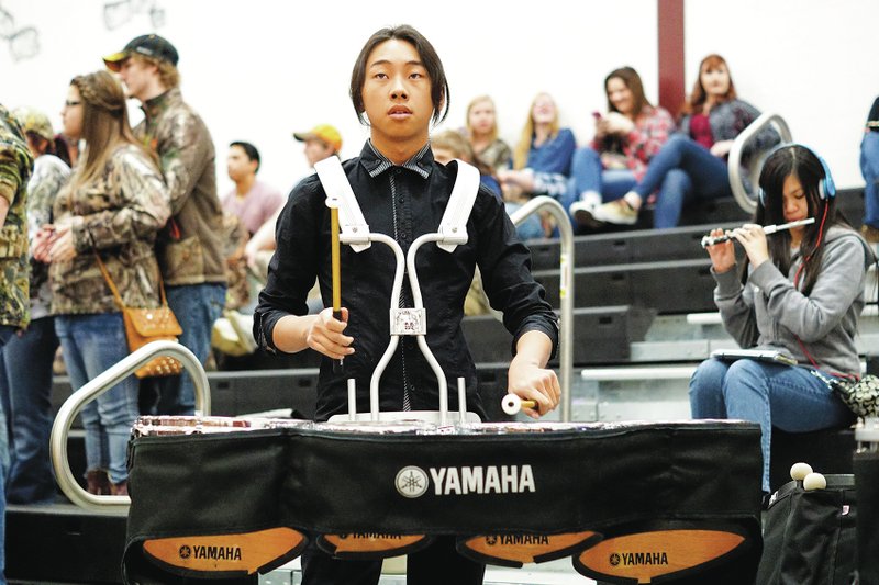 Photo by Randy Moll Ny-kong Yang plays a set of drums during a break in games at Gentry High School on Friday night. Though band members seldom receive much attention, they are there at high school athletic events, lifting fans&#8217; spirits and leading in the support of their teams.