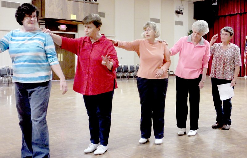 Lynn Atkins/The Weekly Vista The cloggers, including beginners Peggy Wooden and Kris Blackwelder, teacher Kathy Fidler, experienced clogger Marilyn O&#8217;Brien and beginner Marie Anderson, finish by posing in a line across the stage.