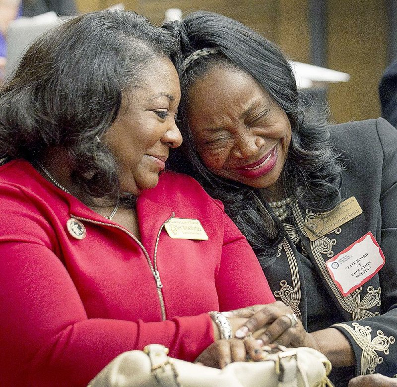 Lee County School District Superintendent Willie Murdock (left) is congratulated by Charity Fleming Smith after the state Board of Education voted to remove the district from the academic distress list. 