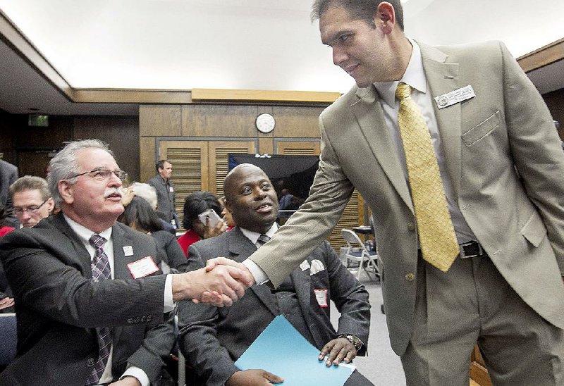 Mike Hernandez (right), deputy education commissioner, greets Dennis Glasgow, (left) associate superintendent for accountability, and Dexter Suggs, interim superintendent of the Little Rock School District, before giving an update on the takeover of the Little Rock district. 