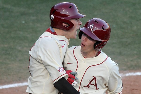 Arkansas base runners Bobby Wernes, left, and Carson Shaddy celebrate after scoring in the bottom of the sixth inning during a game against North Dakota on Friday, Feb. 13, 2015, at Baum Stadium in Fayetteville. 