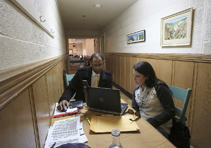 Donald Brown Sr. with the University of Arkansas Partners for Inclusive Communities helps Hope Findlay sign up for health insurance Friday at First Presbyterian Church in Little Rock. The deadline for insurance sign-ups through healthcare.gov is 2 a.m. Central time Monday. 