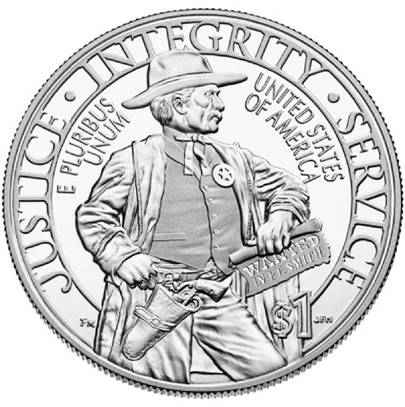The reverse side of the Marshals Service commemorative coin shows a marshal holding a warrant that reads “Wanted in Ft. Smith.” 